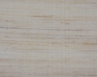 May include: Close-up of a woven fabric with a textured surface. The fabric is a light beige color with subtle variations in tone, creating a natural, organic look. The weave pattern is visible.