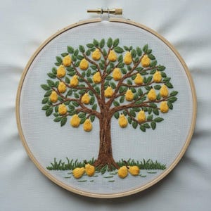 May include: Embroidered artwork of a pear tree in a wooden hoop. The tree features a brown trunk and branches, green leaves, and numerous yellow pears. Green grass and fallen pears are at the base. The background is white.