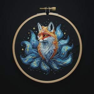 May include: Embroidered artwork of a fox with orange and white fur, surrounded by blue and gold accents, set against a black background. The fox is in a wooden embroidery hoop, creating a framed piece of art.