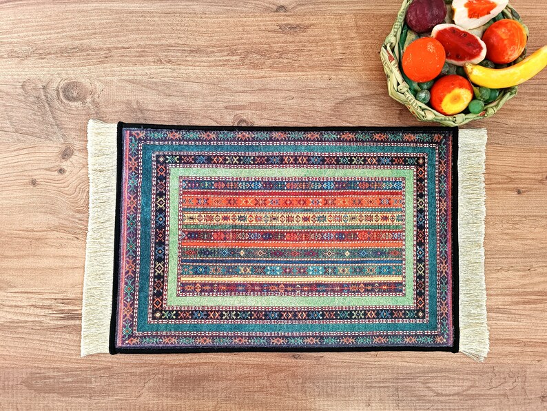 May include: A colorful rug with a geometric pattern and fringe edges. The rug is on a wooden surface.