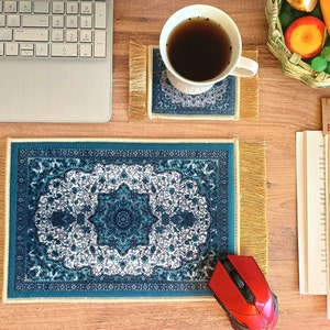 May include: A blue and white patterned mousepad with gold fringe, a red computer mouse, a cup of tea on a blue and white patterned coaster with gold fringe, a book with a bookmark, and a basket of fruit.