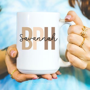 May include: White ceramic mug with a brown, beige, and tan design that reads "BPH Savannah".