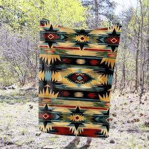 May include: A colorful throw blanket with a geometric pattern in shades of red, yellow, blue, and black. The pattern is reminiscent of Native American designs.