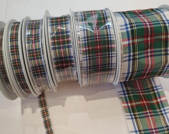 May include: Several spools of plaid ribbon in a variety of sizes. The ribbon features a classic tartan pattern in green, red, blue, and white. The ribbon is on white spools and is suitable for crafts and gift wrapping.