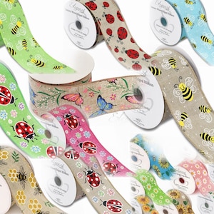 Op de afbeelding: Assortiment van 6,35 cm brede bedrade rand lintrollen met verschillende lentethema-ontwerpen. De ontwerpen omvatten lieveheersbeestjes, bijen, vlinders, zonnebloemen en honingraatpatronen in verschillende kleuren, waaronder groen, roze, blauw en bruin.