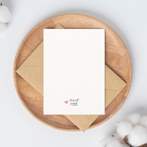 May include: A blank white card with a pink heart and the text "Happy Elf Digital" in black script.