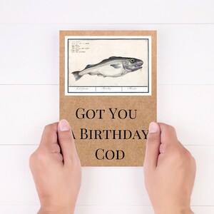 Może przedstawiać: Brązowa kartka z tekstem "GOT YOU A BIRTHDAY COD" i vintage'ową ilustracją dorsza.