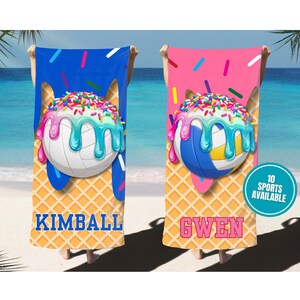 May include: Two beach towels with a volleyball design. One towel is blue, the other is pink. Each towel features a volleyball with ice cream-like dripping details, sprinkles, and the names "KIMBALL" and "GWEN".