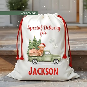 May include: A white drawstring gift bag with red accents and text that reads "Special Delivery for Jackson." The bag features a green truck carrying gifts and a Highland cow wearing a Santa hat, with Christmas trees and snowflakes.