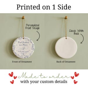 May include: A round ceramic Christmas ornament with a floral design and the text "First Christmas as a Mama." The back is plain white. The ornament hangs from a gold string. The text "Printed on 1 Side" is at the top.