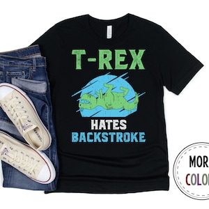 May include: Black t-shirt with a green dinosaur illustration and the text "T-Rex Hates Backstroke".