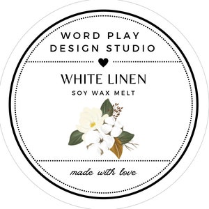 May include: A round, white label with black text and a floral illustration. The label reads "WORD PLAY DESIGN STUDIO" at the top, with "WHITE LINEN SOY WAX MELT" in the center. A floral arrangement of white flowers and green leaves is below the text. The words "made with love" are at the bottom.