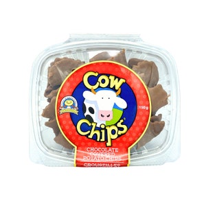 May include: A clear plastic container filled with chocolate covered potato chips. The container has a red and blue label with a cartoon cow and the text "Cow Chips Chocolate Covered Potato Chips Croustilles 150g".
