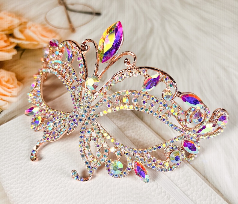 Pu&ograve; includere: Una maschera per gli occhi a forma di farfalla in oro rosa con strass iridescenti. La maschera &egrave; in metallo e ha un design delicato.