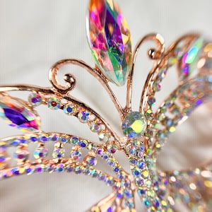 Pu&ograve; includere: Un fermaglio per capelli a forma di farfalla in oro rosa con strass iridescenti. La farfalla ha un design delicato ed &egrave; adornata con cristalli scintillanti.