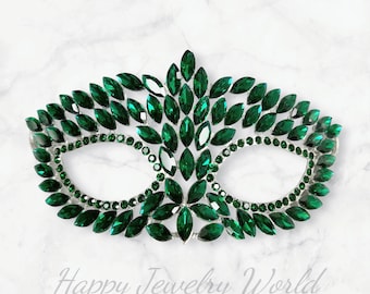 Può includere: Una maschera da ballo verde con cornice argentata e un design di strass verde smeraldo a forma di foglie.