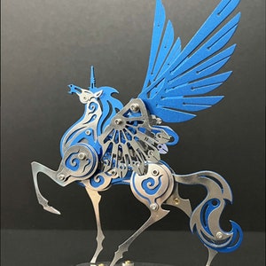 May include: A blue and silver metal sculpture of a winged unicorn. The unicorn has a long, flowing mane and tail, and its wings are spread wide. The sculpture is detailed with intricate designs and is mounted on a silver base.