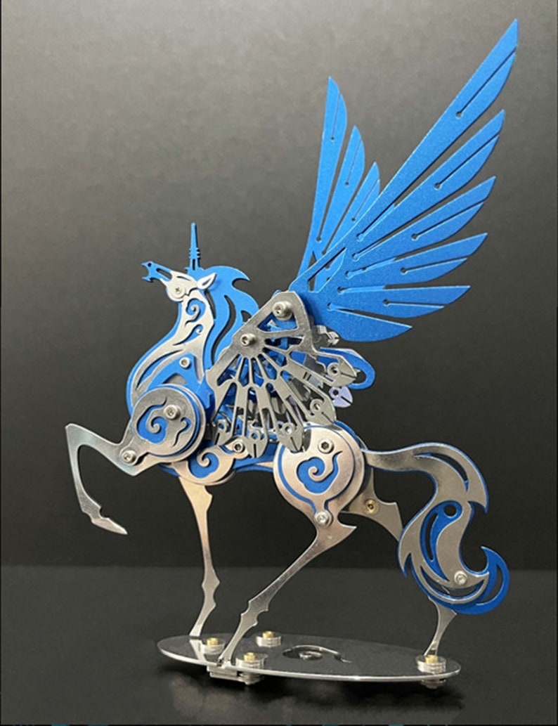 May include: A blue and silver metal sculpture of a winged unicorn. The unicorn has a long, flowing mane and tail, and its wings are spread wide. The sculpture is detailed with intricate designs and is mounted on a silver base.