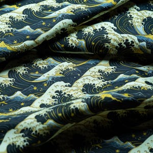May include: Close-up of fabric featuring a repeating pattern of stylized ocean waves. The waves are rendered in navy blue, white, and gold, creating a dynamic and textured appearance. The fabric is suitable for clothing or home decor.