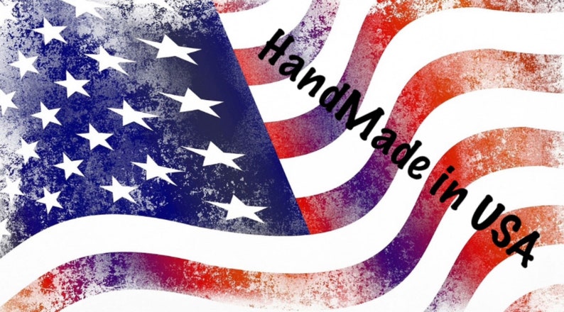 May include: A red, white, and blue American flag with a distressed, faded look. The flag is waving in the wind. The text "Handmade in USA" is written in black on the flag.
