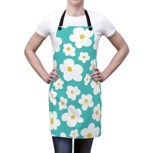 May include: A turquoise blue apron with a white daisy pattern. The daisies have yellow centers.