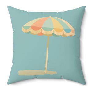 May include: A decorative pillow featuring a colorful beach umbrella design. The umbrella has a scalloped edge and is in shades of orange, yellow, and blue. The background is a solid light blue color.