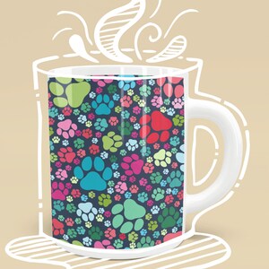 May include: A white ceramic mug with a colorful paw print pattern. The mug is filled with a steaming beverage.
