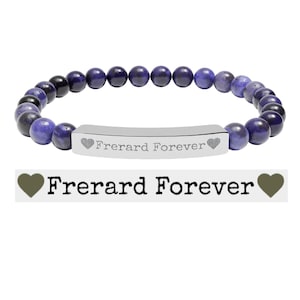 May include: A stretch bracelet featuring round, polished purple and black beads. A central silver-toned metal bar is engraved with the text "Frerard Forever" flanked by two small heart symbols. The same text and heart icons are displayed below the bracelet.