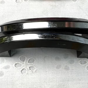May include: Two black and chrome cabinet door handles. The handles are curved and have a polished chrome finish.