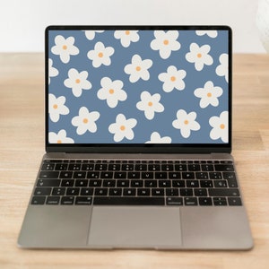 May include: A laptop computer with a blue background and a white daisy pattern on the screen. The laptop is on a wooden table with a cactus and a globe in the background. The text "INDUARTPRINTS.ETSY.COM" is displayed at the top of the screen.