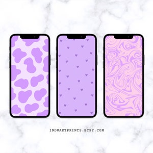 Puede incluir: Tres fondos de pantalla para teléfono con diferentes diseños. El primer fondo de pantalla tiene un diseño de estampado de vaca morado. El segundo fondo de pantalla tiene un fondo morado claro con pequeños corazones morados. El tercer fondo de pantalla tiene un diseño de remolino rosa y morado.