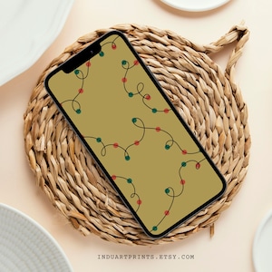 May include: A smartphone displaying a digital wallpaper with a pattern of red and green Christmas lights on a beige background.