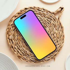 May include: A smartphone with a rainbow gradient background on a woven wicker coaster.