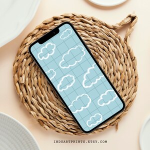 May include: A smartphone displaying a blue and white cloud pattern wallpaper. The phone is on a woven straw coaster.