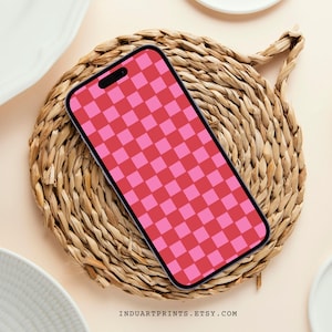 Könnte beinhalten: Eine Handyhülle mit pink-rotem Karomuster auf einem geflochtenen Strohteller.