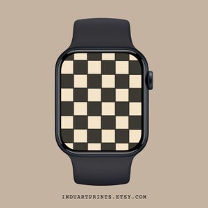 May include: A black Apple Watch with a checkered watch face. The watch face is black and white.