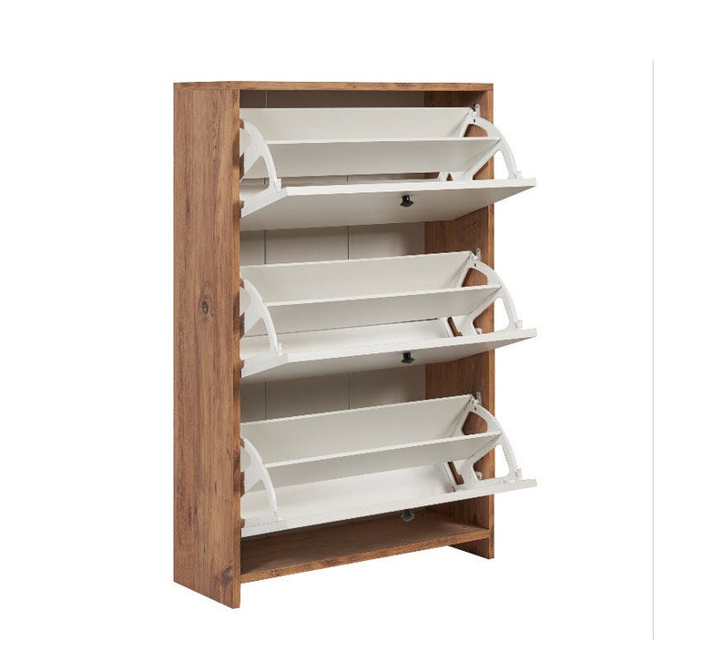 May include: A brown wooden shoe cabinet with three white shelves that pull out. The shelves are designed to hold shoes.
