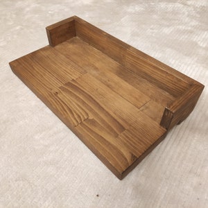 May include: A wooden shelf with a rectangular cutout, perfect for displaying small items. The shelf is made of natural wood with a dark brown stain.