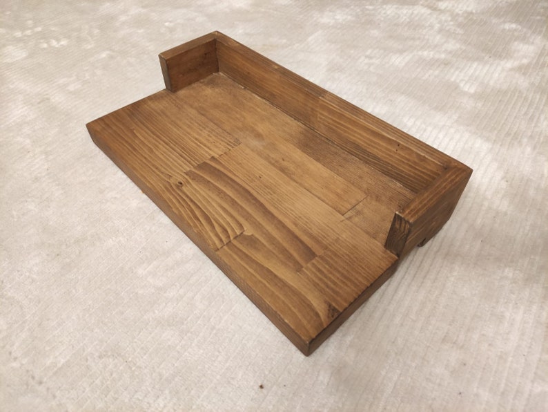 May include: A wooden shelf with a rectangular cutout, perfect for displaying small items. The shelf is made of natural wood with a dark brown stain.