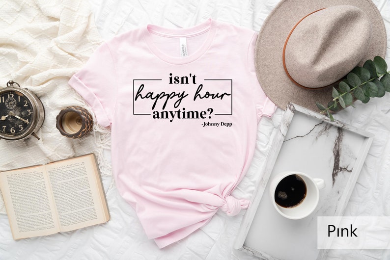 May include: Pink t-shirt with the text "isn't happy hour anytime? -Johnny Depp" printed on it.