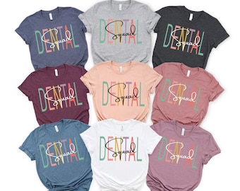 May include: Seven t-shirts in different colors with the text "Dental Squad" in colorful letters and a white outline. The text is arranged vertically with the word "Dental" at the top and "Squad" at the bottom.