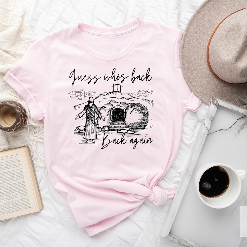 May include: Pink t-shirt with a black and white illustration of Jesus walking out of a tomb with the text "Guess who's back back again".