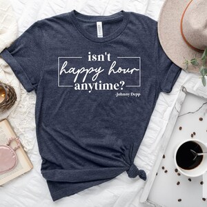 May include: A navy blue t-shirt with the text "isn't happy hour anytime? - Johnny Depp" printed in white.