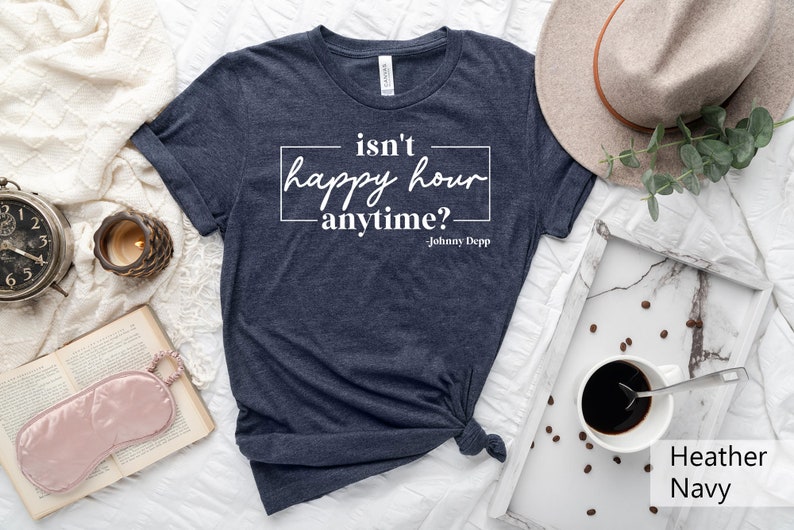 May include: A navy blue t-shirt with the text "isn't happy hour anytime? - Johnny Depp" printed in white.