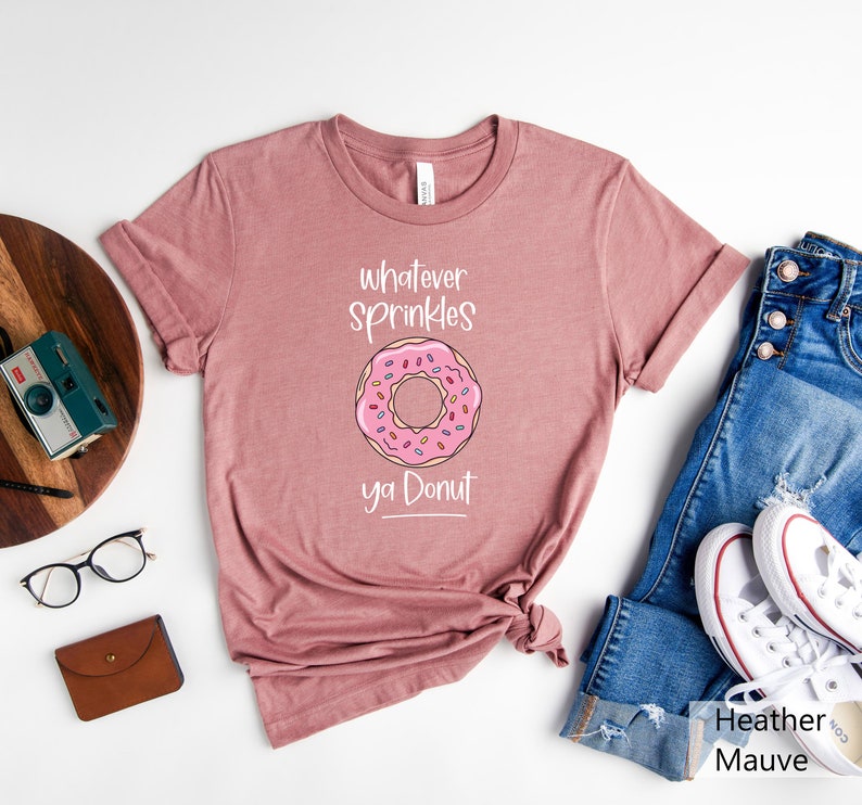 May include: A heather mauve t-shirt with a pink donut graphic and the text "whatever sprinkles ya donut".