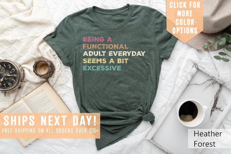 May include: Green t-shirt with the text "Being a Functional Adult Everyday Seems a Bit Excessive" in rainbow colors.