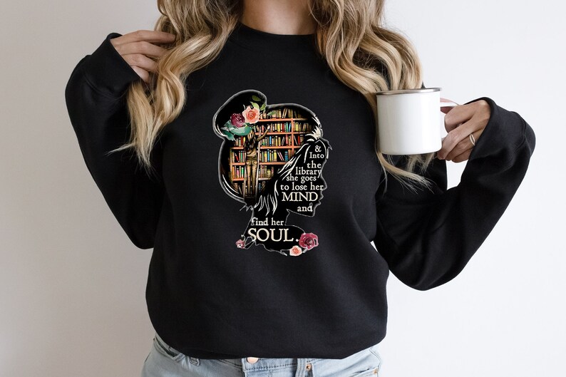 May include: Black sweatshirt with a graphic of a woman standing in a library with the text "& Into the library she goes to lose her MIND and find her SOUL."