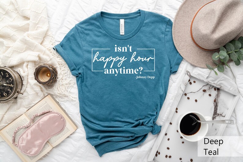 May include: A teal blue t-shirt with the text "isn't happy hour anytime? - Johnny Depp" printed in white.