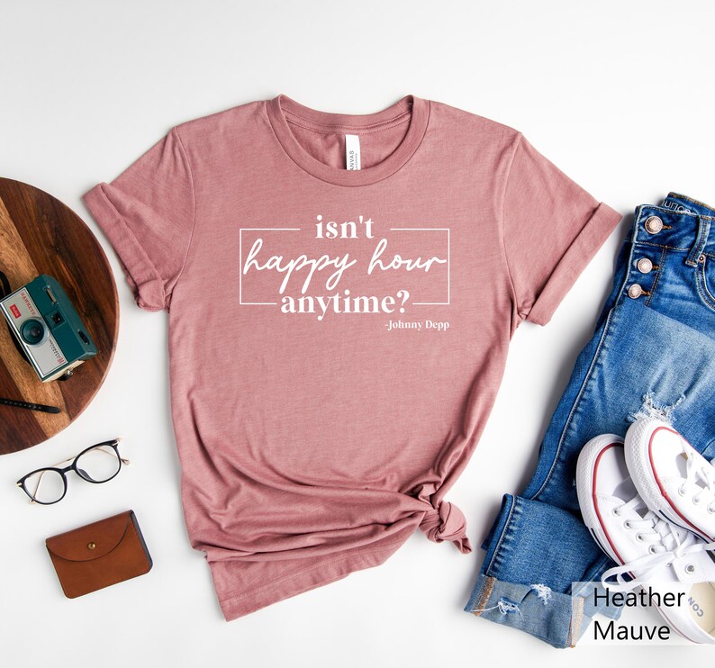 May include: Heather mauve t-shirt with the text "isn't happy hour anytime? - Johnny Depp" printed in white.