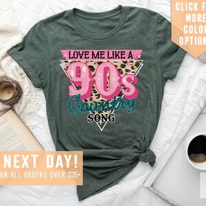 May include: Green t-shirt with a pink triangle graphic that says "Love Me Like A 90's Country Song" with a leopard print background.